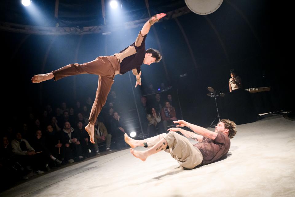 two acrobats and musician on stage