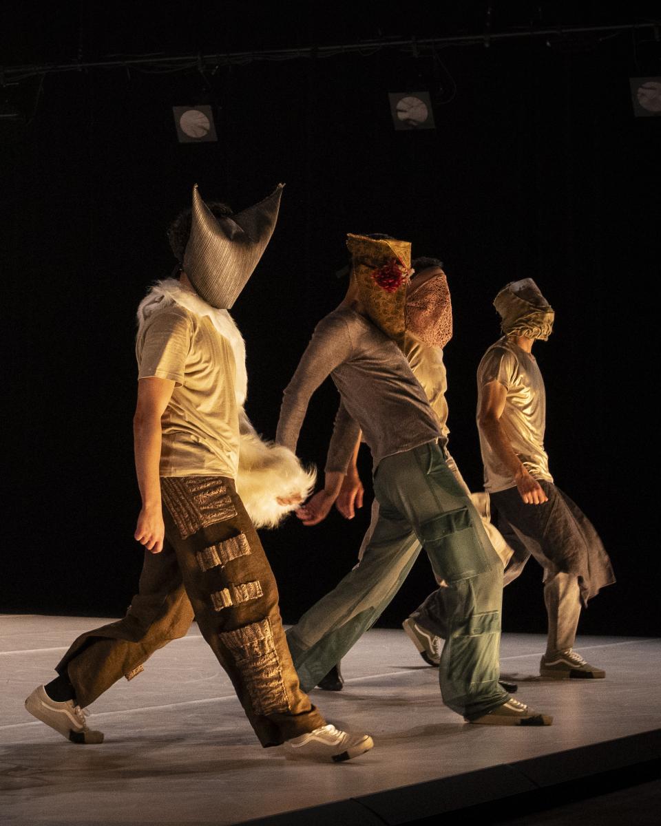 dancers with masks walk in a line
